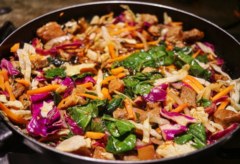 Colorful stir-fry of beef and mixed vegetables in a pan, showcasing fresh ingredients.